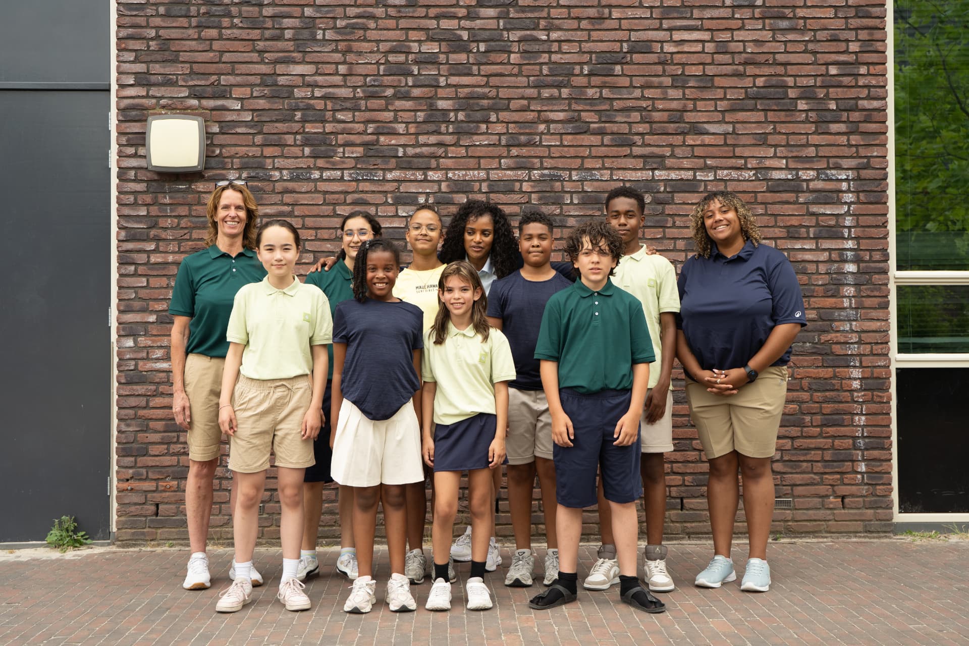 Leerlingen en leerkrachten samen op de foto bij het schoolgebouw